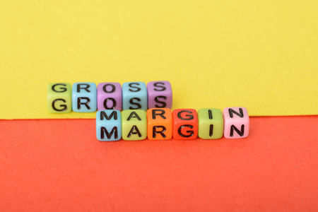 Alphabet beads with text GROSS MARGIN. Gross margin is the percentage of revenue left over after you subtract your company's direct costsの写真素材
