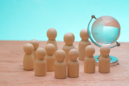 The wooden figures encircling together, highlighted the synergy among teammates, emphasizing the strategic vision needed to navigate the complexities of a global business landscapeの写真素材