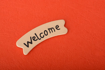 Wooden label with text WELCOME on a red background.の写真素材