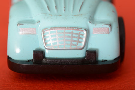 The close-up of a toy retro car highlights its miniature charm, offering a glimpse into the vintage...