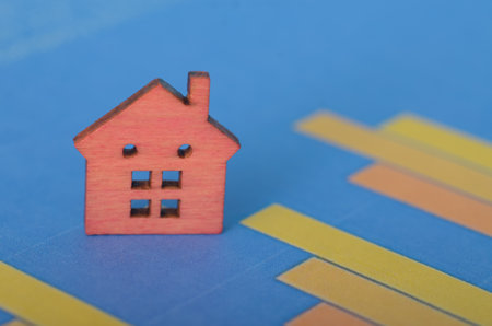 A home property alongside a fluctuating graph illustrates the impact of market volatility on real estate values and investment opportunitiesの写真素材