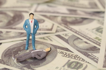 a thriving businessman next to his fallen peers highlights the stark contrast between success and failure in the competitive world of finance.の写真素材