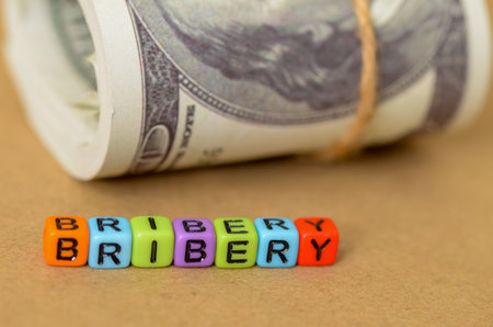 The image depicts the corrupt nature of bribery, where financial incentives are used to influence decisions and undermine ethical principles.の写真素材