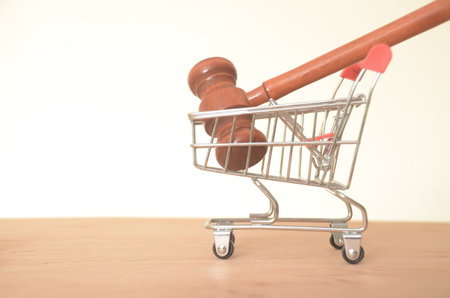 The image of a gavel in a shopping cart suggests the intersection of consumerism and legal matters.の写真素材