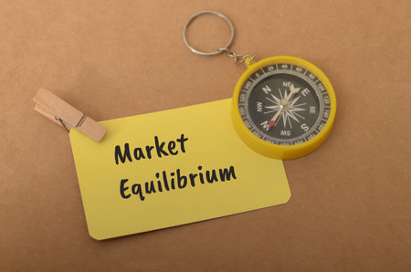 the concept of market equilibrium, with the words Market Equilibrium written on a notecard and a...