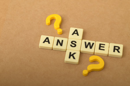 The image visually represents the relationship between asking questions and finding answers, with the letters forming the word "ANSWER" intersecting with question marks.の写真素材