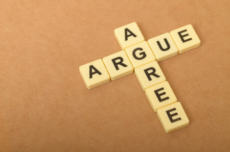 the contrast between arguing and agreeing, with the letters forming the words "ARGUE" and "AGREE" arranged in a conflicting manner.の写真素材