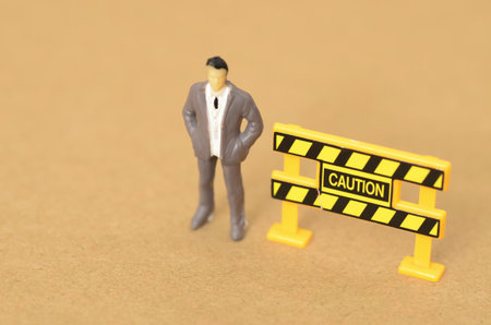 The caution sign, clearly visible to the businessman standing nearby, warned of potential danger.