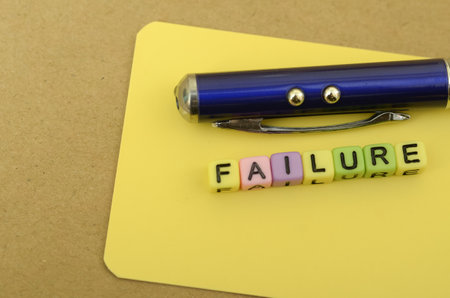 The image visually represents the concept of failure, symbolized by the word FAILURE spelled out in...