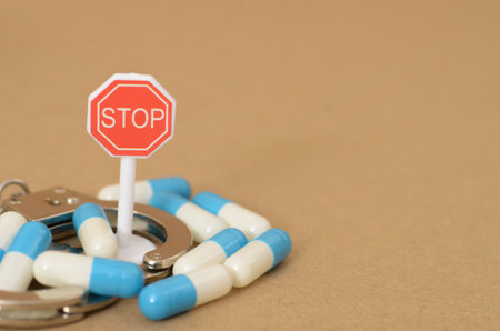 The stop sign warning danger loomed ahead, but the man ignored it, driving straight into a world of illegal pill capsules and drug crimeの写真素材