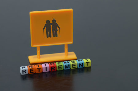 The vibrant yellow sign, featuring a silhouette of an elderly couple, symbolizes the anticipation and excitement of retirement.の写真素材