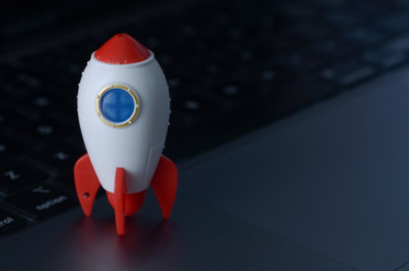 The miniature rocket, positioned on a laptop keyboard, symbolizes the potential for rapid growth, innovation, and success in the digital age.の写真素材