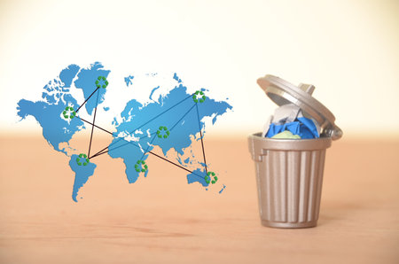 The interconnected recycling symbols on the world map symbolize the global effort to manage waste...