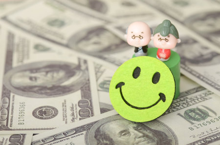 The image represents a positive and fulfilling retirement, symbolized by the smiling faces of the elderly couple and the abundance of money.の写真素材