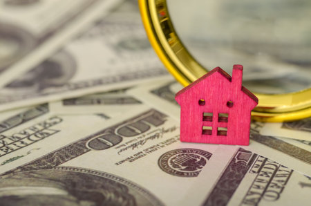 The magnifying glass acts as a metaphor for the scrutiny involved in evaluating property values, location, and potential returns.の写真素材