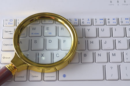 The combination of a magnifying glass and a keyboard could symbolize the use of technology as a tool...