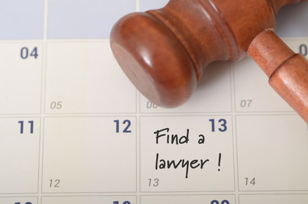 a pressing need for legal assistance, as evidenced by the gavel and the handwritten message "Find a lawyer!" on the calendar.の写真素材