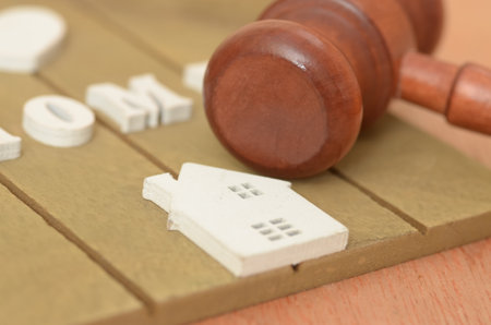 The combination of the gavel and the house suggests that legal considerations are essential in real estate transactions, such as buying, selling, renting, or financing.の写真素材