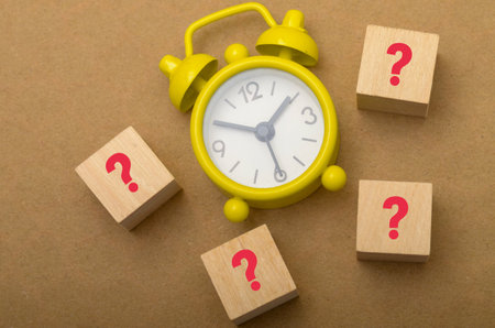 Question Marks and Clock: Symbolizing Time Management and Uncertainty in Decision-Makingの写真素材