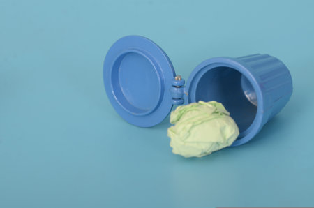 Environmental Concern: Paper Trash Scattered Around an Overflowing Binの写真素材