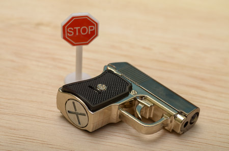 the toy gun and the stop sign serves as a visual reminder of the potential dangers associated with firearms.の写真素材