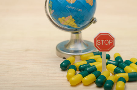 Global Health Awareness: Pill Capsules and Stop Sign on World Globe