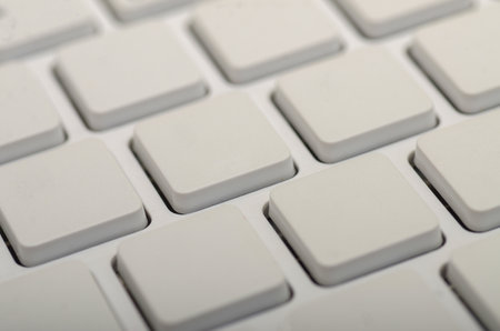 A close-up view of a minimalist white keyboard showcasing its clean, square keycaps in a grid pattern.の写真素材