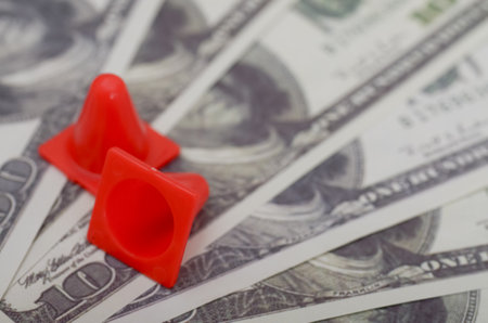 Financial Caution: The Symbolism of Traffic Cones and Moneyの写真素材