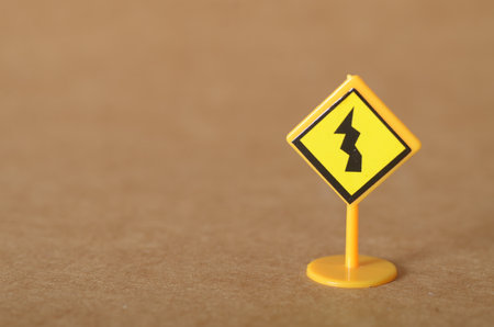 Bright Yellow Zigzag Road Sign Warning of Sharp Turn Aheadの写真素材