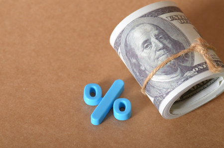 Financial Concept Image: Cash Roll with Percentage Symbol on Textured Surfaceの写真素材