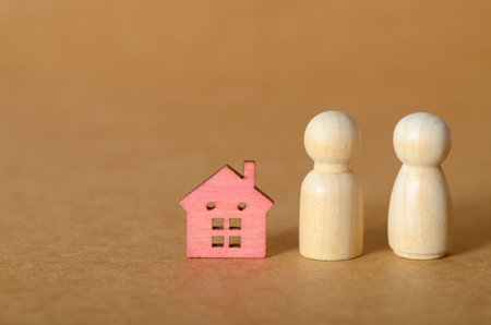 Minimalist Wooden House and Peg Dolls Symbolizing Family and Home Conceptの写真素材
