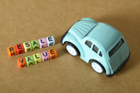 Toy Car and Beads Spelling 'Resale Value' â Symbolizing Used Car Marketの写真素材