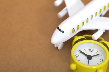 Travel Time Management Symbolized by Alarm Clock and Toy Plane on Neutral Surfaceの写真素材