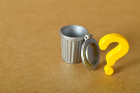 Minimalist Concept of Waste and Value â Empty Garbage Bin with Question Mark Suggests Uncertaintyの写真素材