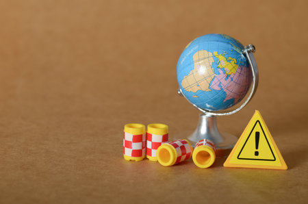 Global Warning Concept with Hazard Sign and Checkered Cylinders Near Globeの写真素材