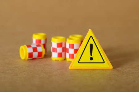 Warning Sign with Scattered Hazard Cylinders on Ground â€“ Safety Alert Concept