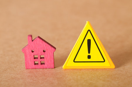 Caution in the Housing Market: Visual Metaphor Using Wooden House and Warning Signの写真素材