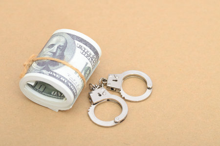 Bribery and Corruption Concept with Money Bundle and Open Handcuffs Ready for Arrest