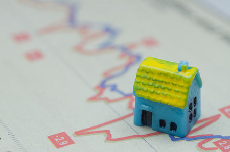 Economic Instability and Real Estate Values Symbolized by Mini House on Graphの写真素材