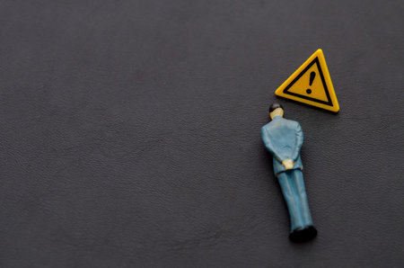Corporate Outsider: Single Employee Highlighted by Warning Symbolの写真素材
