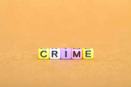 CRIME spelled with colorful letter beads on light brown background â law violation conceptの写真素材