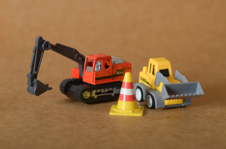 Heavy Equipment at Work: Orange Excavator and Yellow Loader in a Miniature Construction Zone.