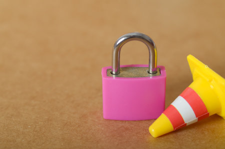 Conceptual Security: A Bright Pink Padlock and Traffic Cone Symbolizing Protection, Restricted...