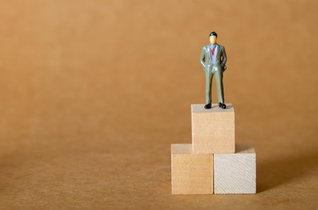 a professional reaches the top of a block structure, a powerful metaphor for ambition, growth, and leadership.の写真素材