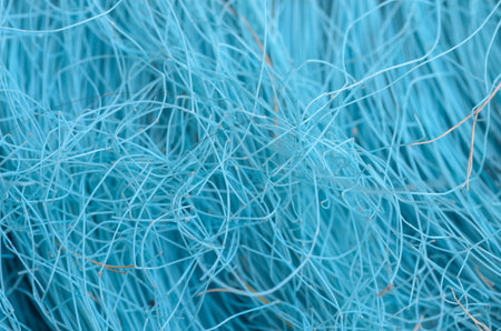 This detailed close-up reveals a dense network of intertwined, wiry synthetic fibers, symbolizing...