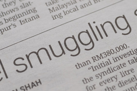A close-up photograph of a newspaper with "smuggling" in a bold headline, highlighting themes of illegal activity, crime, and investigative journalism.の写真素材