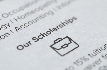 A printed document titled Our Scholarships in sharp focus, symbolizing opportunities for academic...