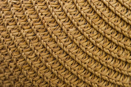 A close-up macro shot showcasing the intricate, handmade texture of a woven straw hat or basket, perfect for rustic and earthy themes.の写真素材