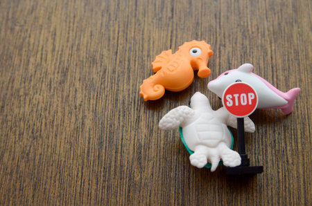A powerful conceptual image featuring a "STOP" sign alongside a toy sea turtle, dolphin, and seahorse, symbolizing an urgent call to action for marine wildlife protection.の写真素材