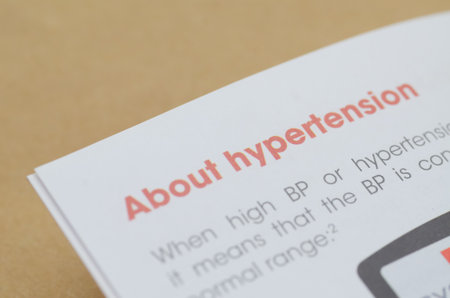 A medical brochure with the red heading About hypertension in sharp focus, providing educational...